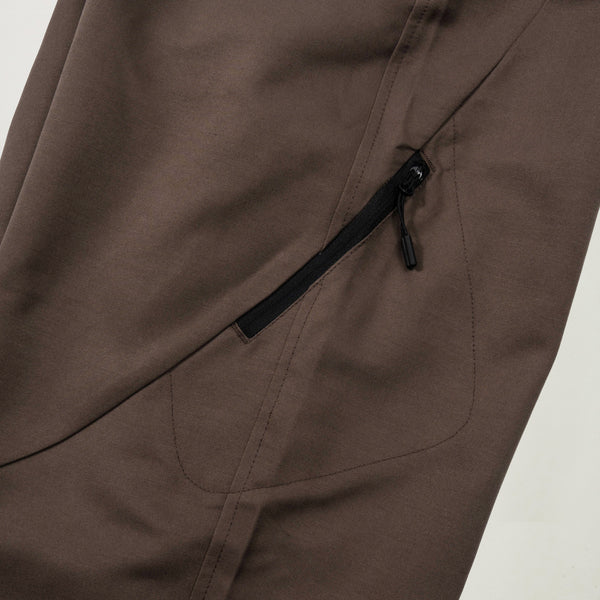 Brown pants with a zipper pocket on a light gray background