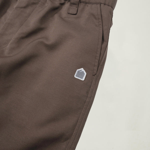 Brown pants with a small logo on a light gray background