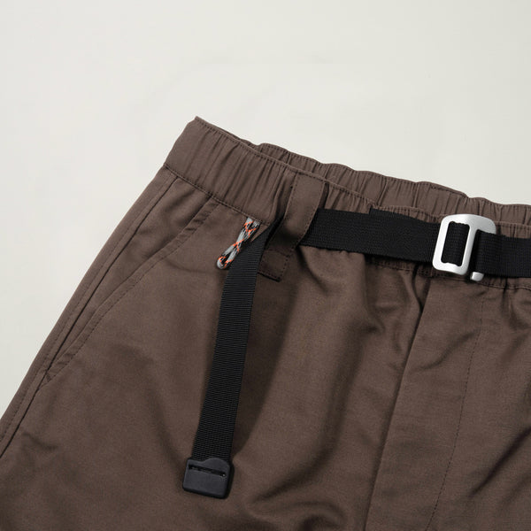 Brown pants with black straps and a buckle on a light gray background