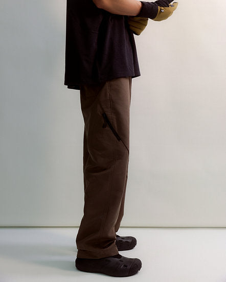 Person wearing brown pants and shoes on a plain background