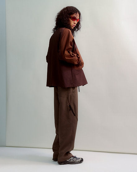 Person wearing a brown outfit against a white background