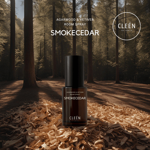 Room spray bottle labeled 'Smokecedar' by Cleén in a forest setting