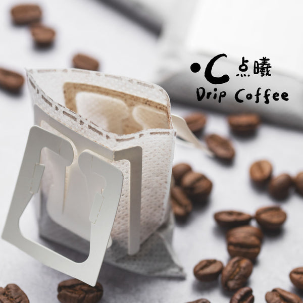 Drip coffee filter with coffee beans on a light surface, featuring the brand 'Drip Coffee'.