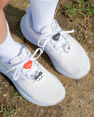 White sneakers with decorative elements on a concrete surface