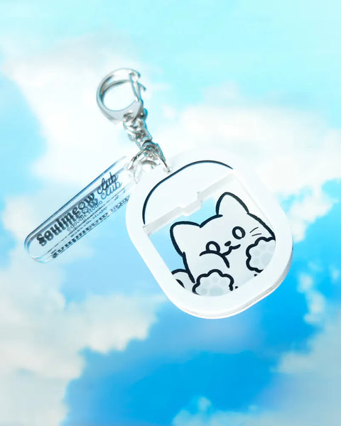 Keychain with a cat design against a blue sky background