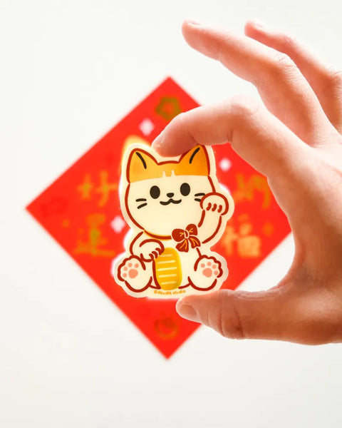 Hand holding a red envelope with a cartoon cat design on a white background