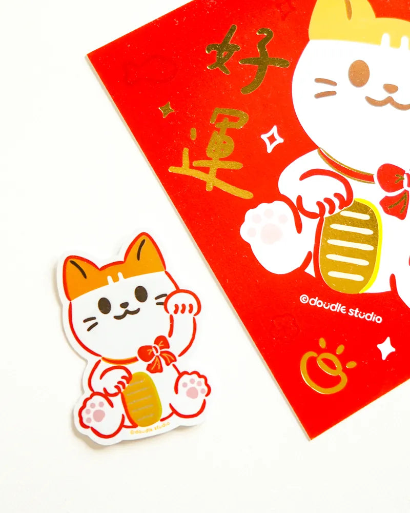 Maneki-neko cat sticker and red envelope with gold text on a white background