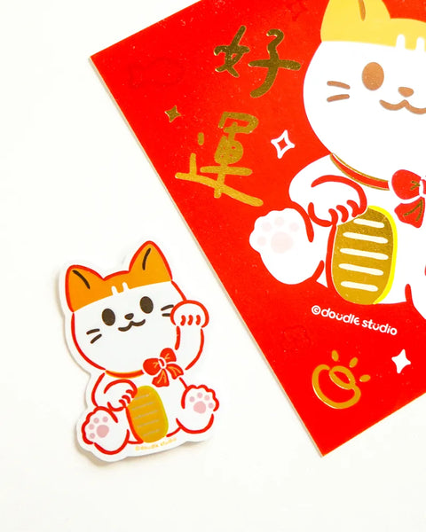 Maneki-neko cat sticker and red envelope with gold text on a white background