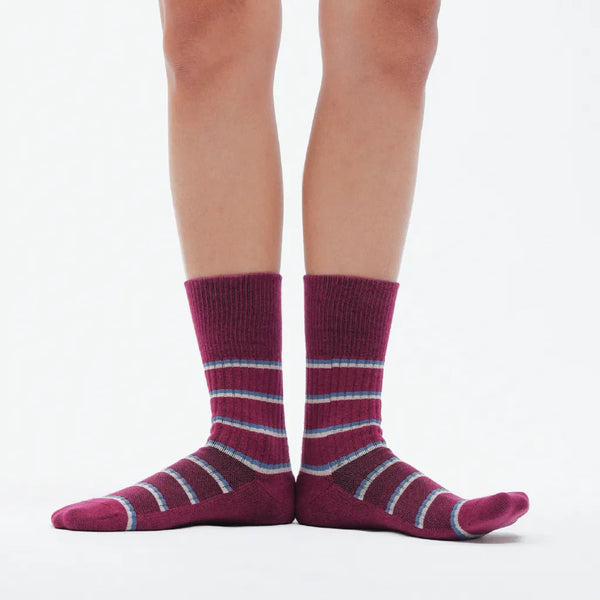 Purple striped socks worn by a person on a white background