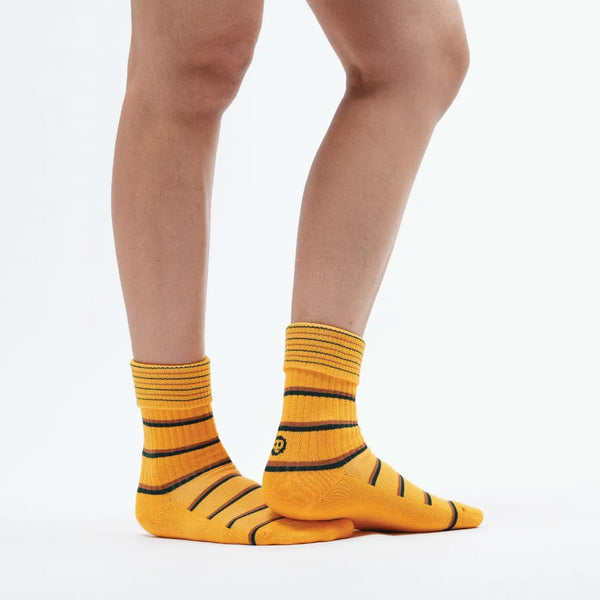 Yellow striped socks worn by a person on a white background