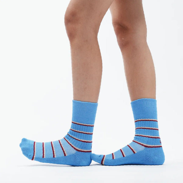 Blue striped socks worn by a person on a white background