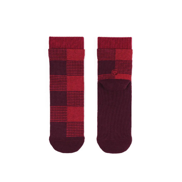 Two red and burgundy checkered socks on a white background