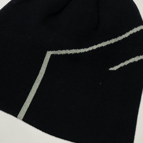 Close-up of a black sock with white stitching on a light gray background