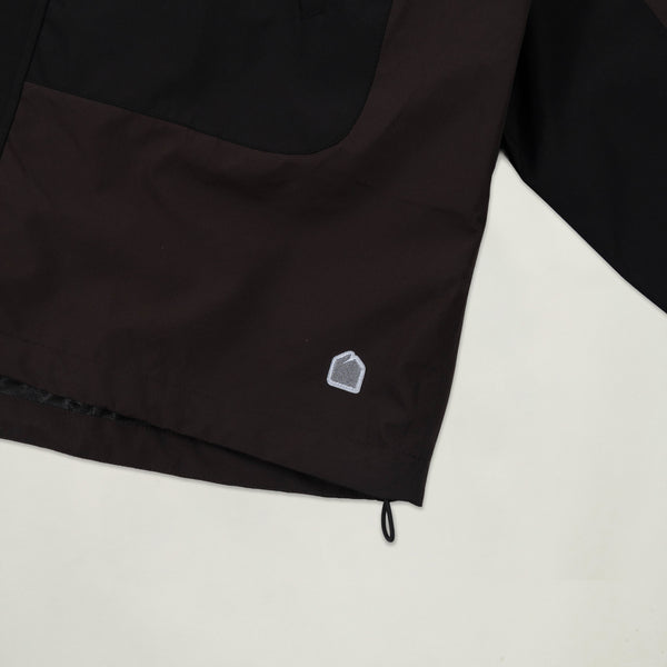 Black jacket with a small white logo on a light gray background