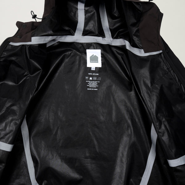 Black raincoat with reflective stripes and a visible brand label on a light gray background