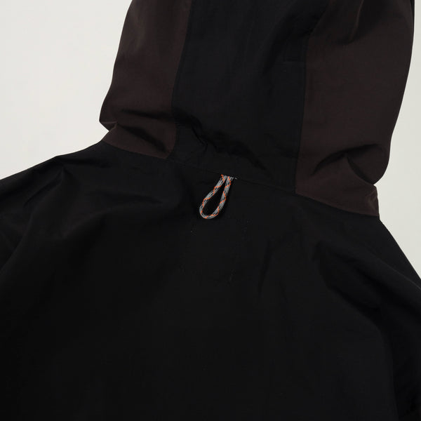 Close-up of a black hooded jacket with a white background