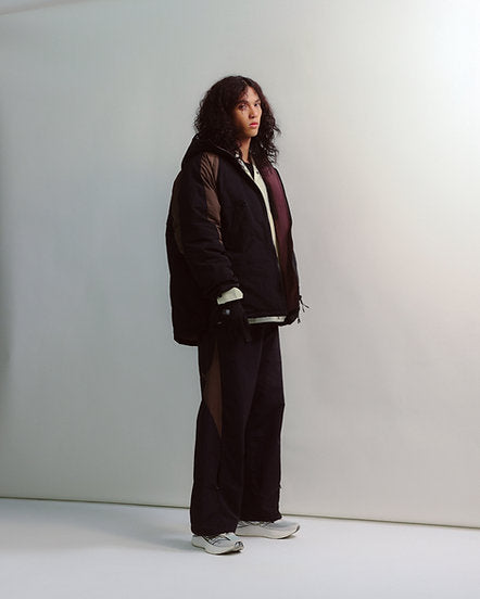 Person wearing a dark outfit with a white background