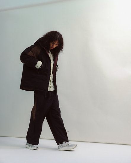 Person wearing a dark outfit with a white background