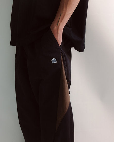 Black outfit with a small logo on a plain background