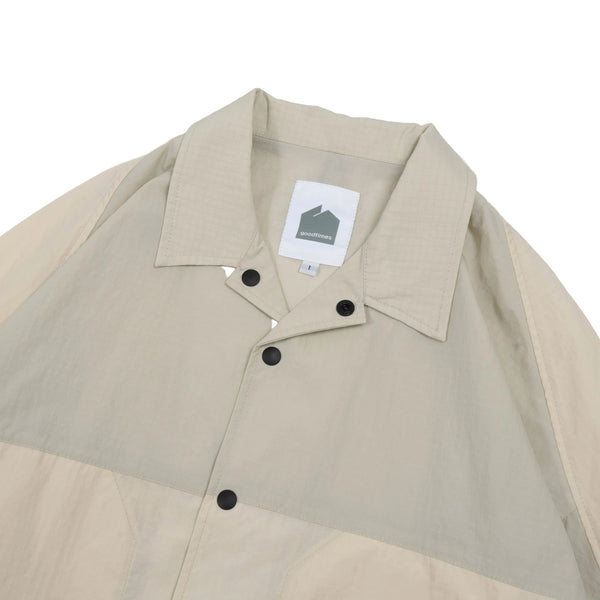 Beige and green jacket with a brand label on a white background