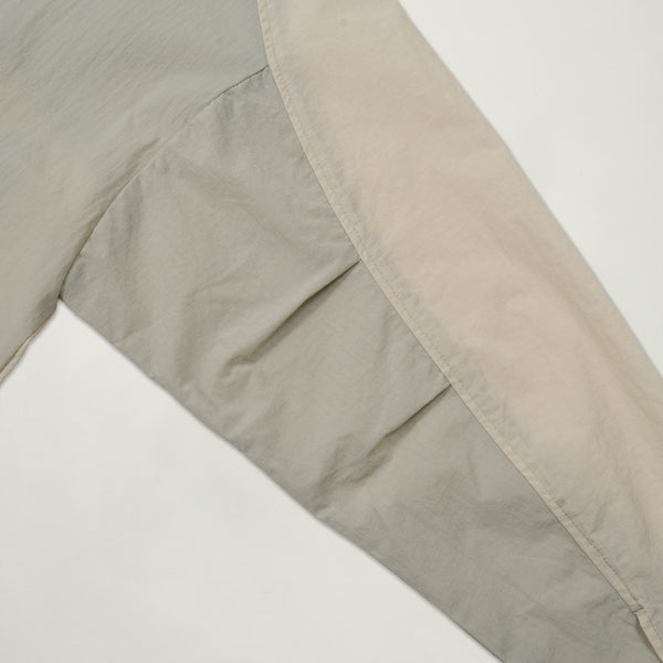 Close-up of a quilt with beige and brown patchwork on a white background