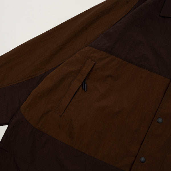 Close-up of a brown jacket with a pocket and buttons on a white background