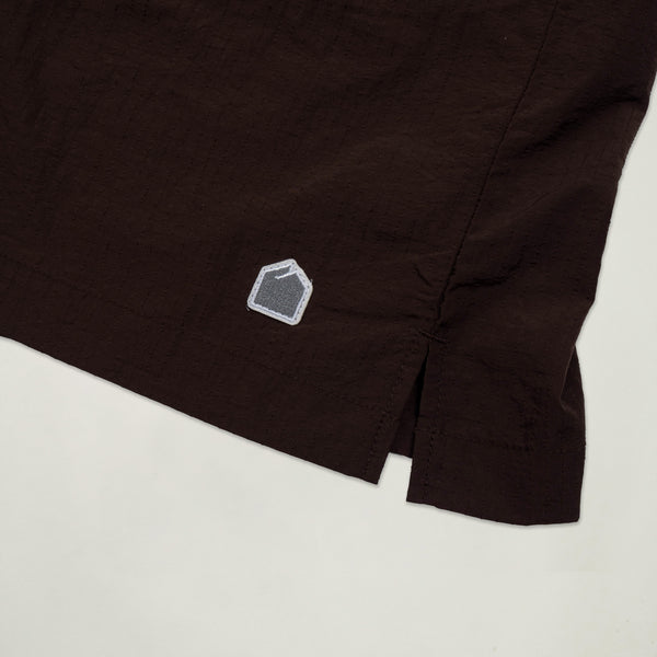 Close-up of a black garment with a small logo on a light background