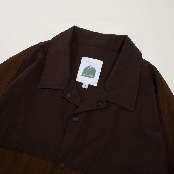 Brown jacket with a brand label on a light gray background