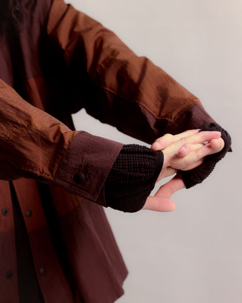 Brown coat with fingerless gloves on a plain background