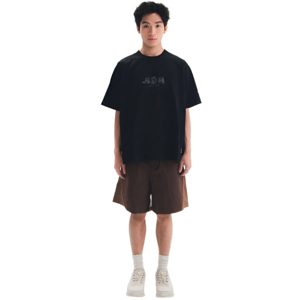 Person wearing a black t-shirt and brown shorts on a white background