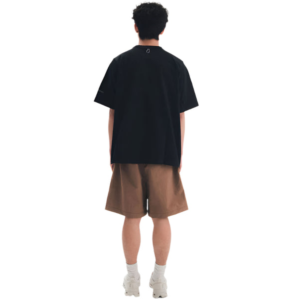 Person wearing a black t-shirt and brown shorts on a white background