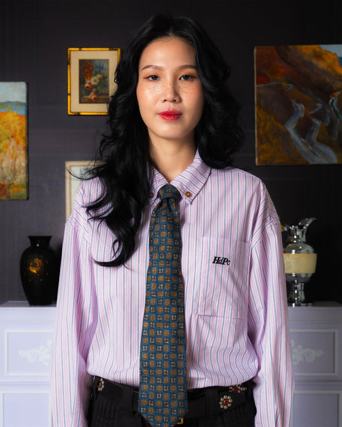 Woman wearing a striped shirt and tie in an art gallery setting
