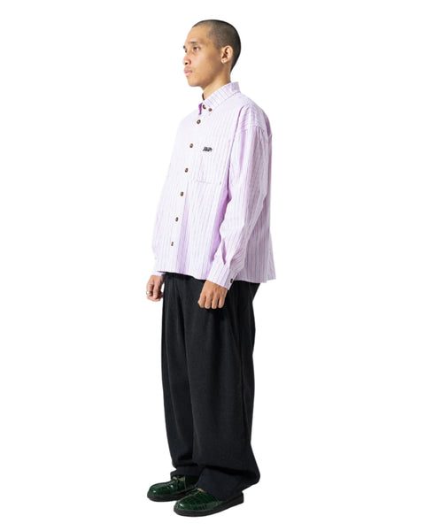Man wearing a light purple striped shirt and black pants on a white background