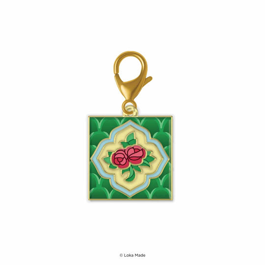 Gold charm with green background and red rose design on a white background