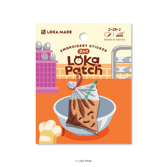Loka Patch embroidery sticker packaging with a design of a bag with a face on a plate.