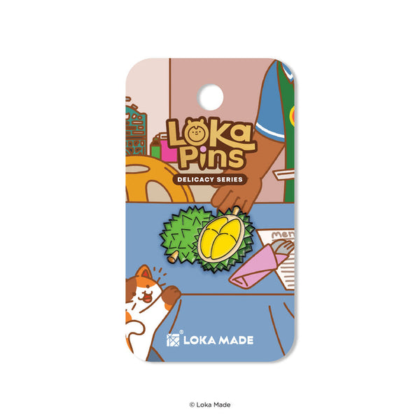 Loka Pins durian pin on a colorful card with cartoon illustrations