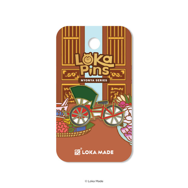 Loka Pins Nyonya Series packaging with a bicycle illustration on a brown background