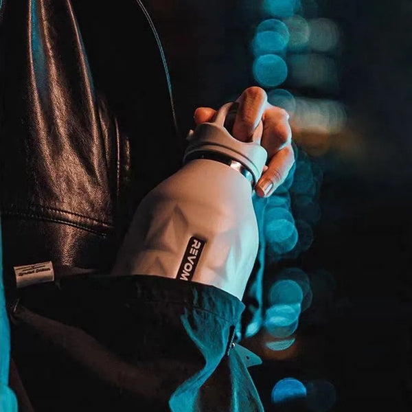 Close-up of a hand wearing a glove with a brand logo against a blurred background