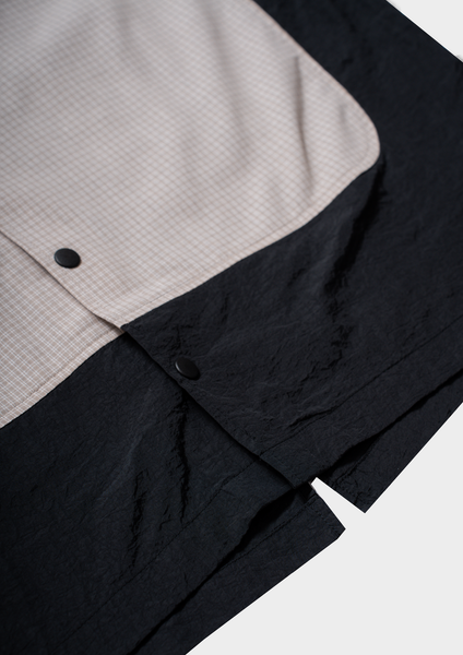 Close-up of a black and gray shirt with buttons on a white background