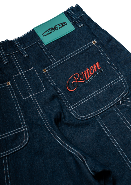 Dark blue jeans with 'Rotten' embroidery on a white background