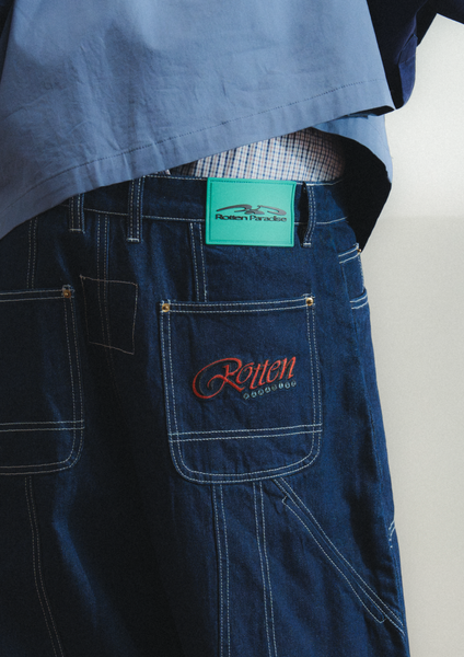 Blue work pants with a logo on the pocket against a white background