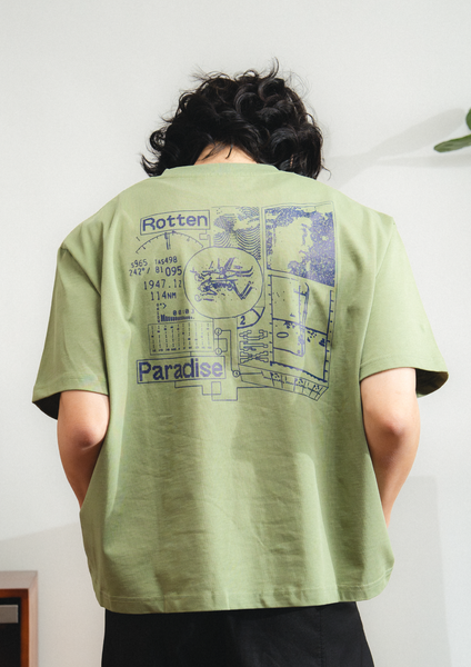 Person wearing a green t-shirt with graphic designs and text on the back.