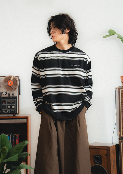 Person wearing a black and white striped sweater in a room with vintage equipment.