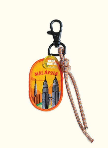 Keychain with Malaysia design featuring the Petronas Towers on an orange background.