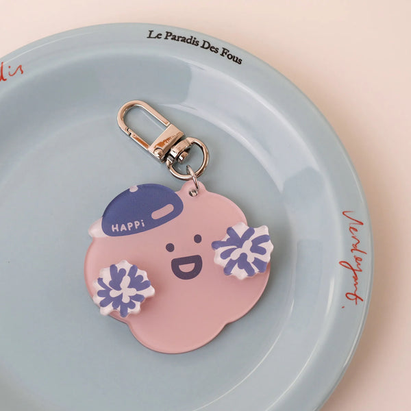 Pink keychain with floral designs on a light blue plate