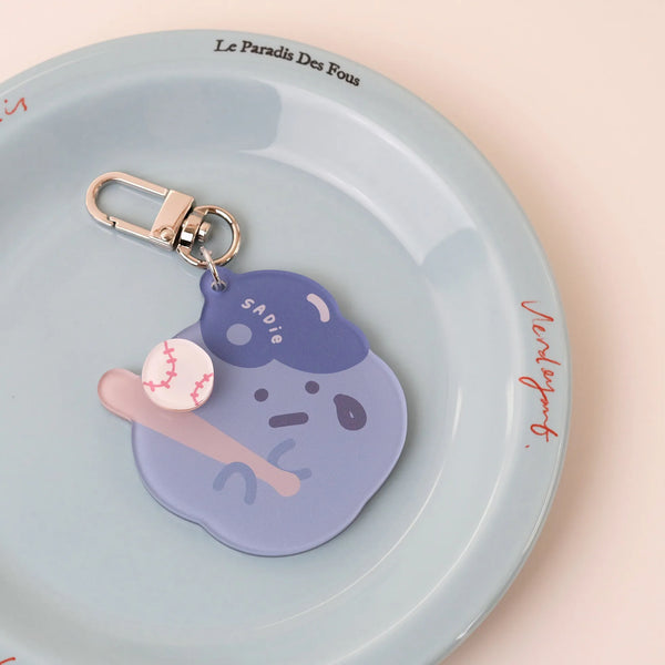 Keychain with a sad character design on a light blue plate