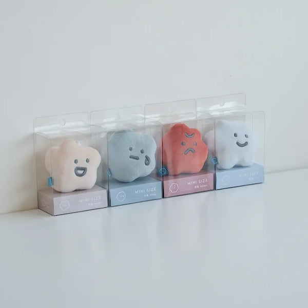 Four small plush toys in clear packaging on a white surface