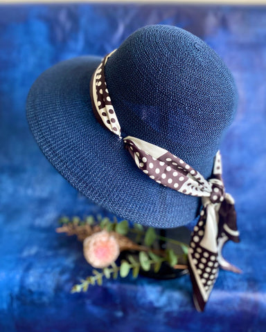 Blue straw hat with a decorative band on a blue textured background
