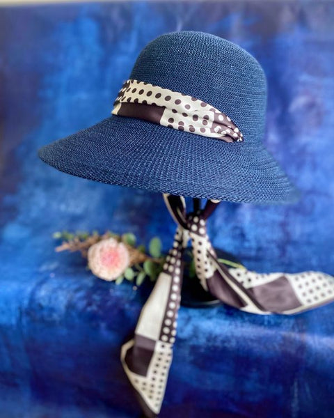 Blue straw hat with a decorative ribbon on a blue background